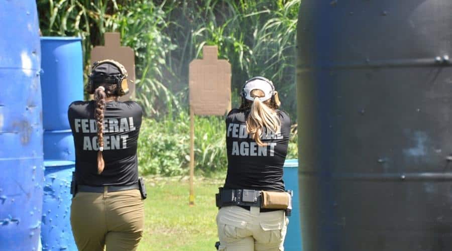 Photo from behind of two female DSS Special Agents at target practice